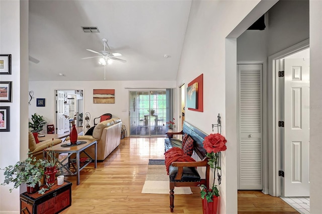 living room featuring ceiling fan, lofted ceiling, and light hardwood / wood-style floors