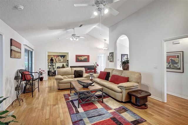 living room with light hardwood / wood-style floors, ceiling fan, and lofted ceiling