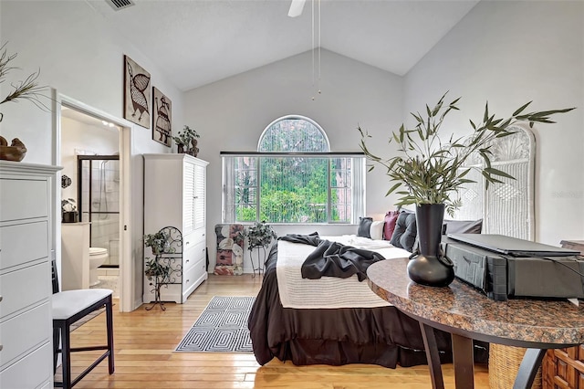 bedroom with connected bathroom, light wood-type flooring, and high vaulted ceiling