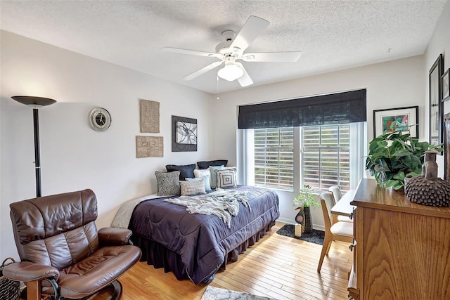 bedroom with ceiling fan, a textured ceiling, and wood-type flooring