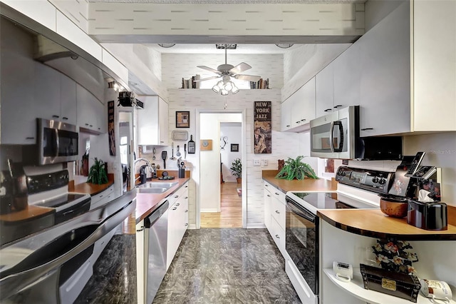 kitchen featuring dark wood-type flooring, white cabinetry, sink, and appliances with stainless steel finishes