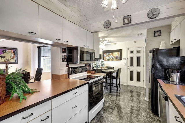 kitchen featuring stainless steel appliances, dark wood-type flooring, a textured ceiling, ceiling fan, and white cabinetry