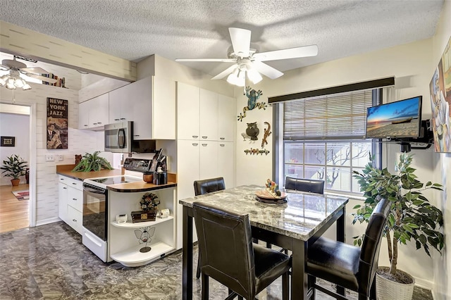 dining space featuring ceiling fan, a textured ceiling, and dark hardwood / wood-style flooring