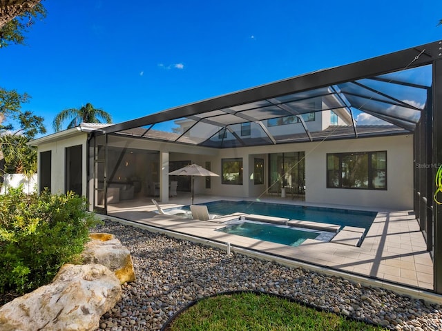 view of pool with an in ground hot tub, a patio, and glass enclosure