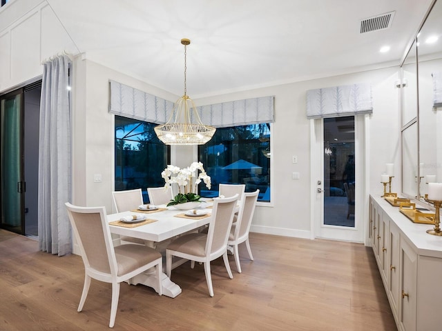 dining area featuring light hardwood / wood-style flooring and a chandelier