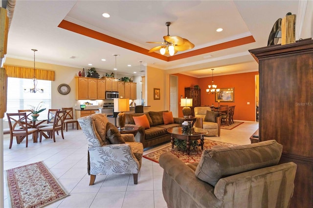 living room featuring ceiling fan with notable chandelier, a raised ceiling, ornamental molding, and light tile patterned floors