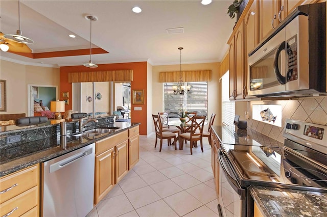 kitchen with sink, hanging light fixtures, backsplash, crown molding, and appliances with stainless steel finishes