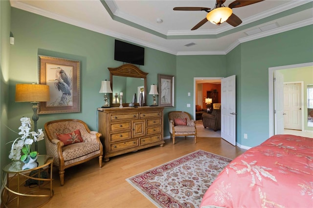 bedroom featuring a raised ceiling, ceiling fan, crown molding, and hardwood / wood-style floors