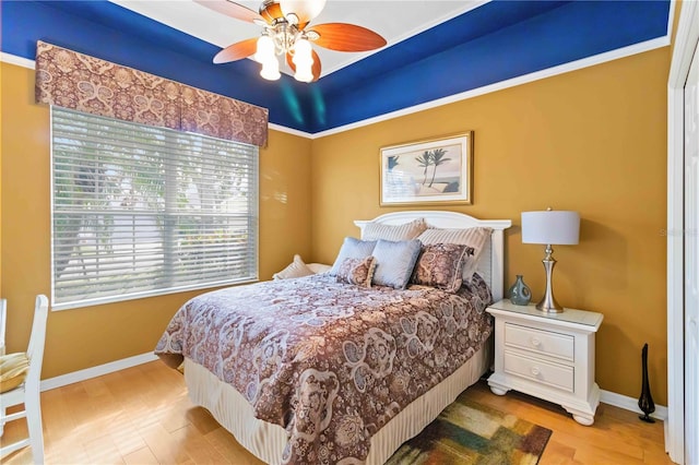 bedroom featuring ceiling fan, light hardwood / wood-style flooring, and ornamental molding