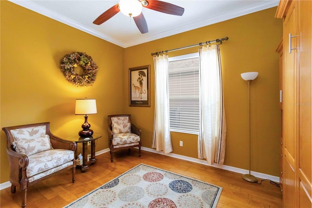 living area featuring ceiling fan, light wood-type flooring, and ornamental molding