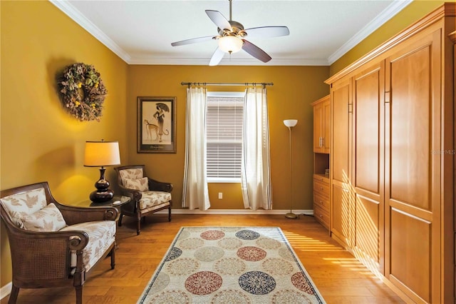 sitting room with ceiling fan, crown molding, and light hardwood / wood-style flooring