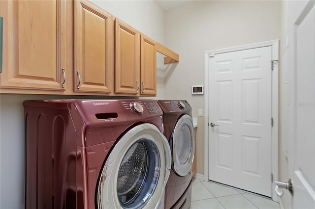 laundry room with cabinets, light tile patterned floors, and separate washer and dryer