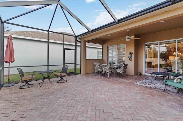 view of patio / terrace featuring ceiling fan and glass enclosure