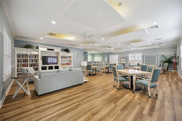 dining room with ceiling fan, crown molding, and light wood-type flooring