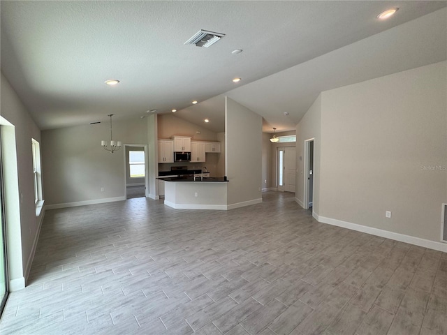 5605 Gaffney Ave, North Port, FL 34291 - unfurnished living room featuring lofted ceiling, a chandelier, recessed lighting, and light wood-style floors
