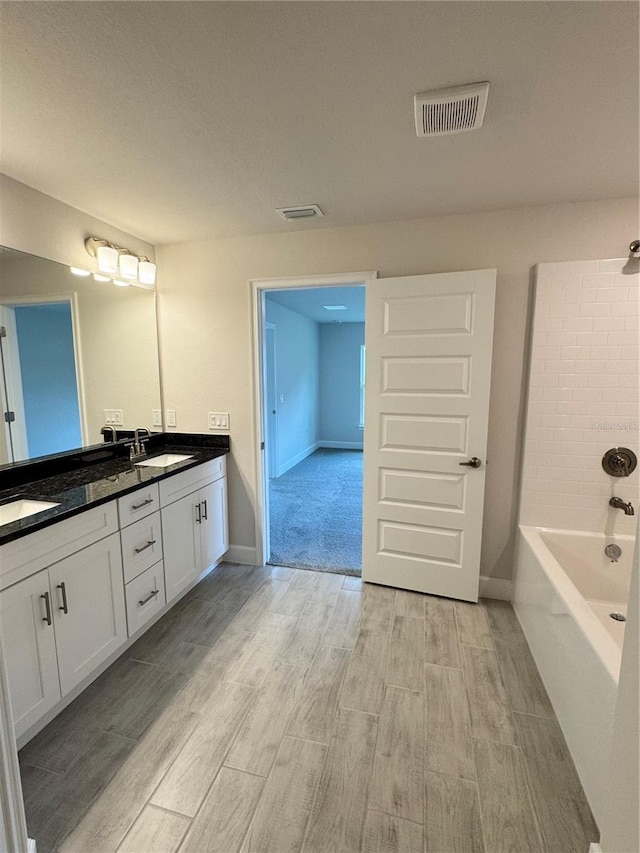5605 Gaffney Ave, North Port, FL 34291 - bathroom featuring wood finished floors, double vanity, and bathtub / shower combination