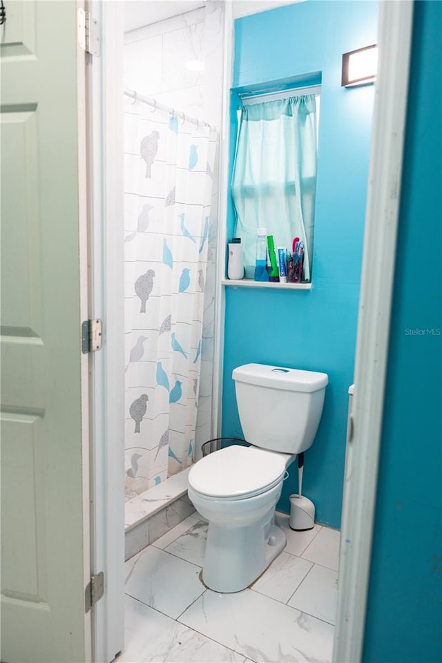 bathroom with toilet and a shower with shower curtain