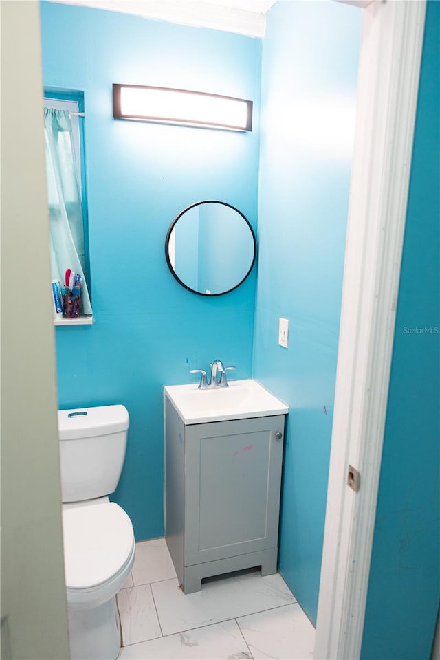 bathroom featuring vanity, toilet, and crown molding