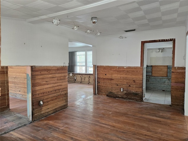 empty room featuring wood-type flooring and wooden walls