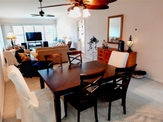 dining space with ceiling fan and light carpet