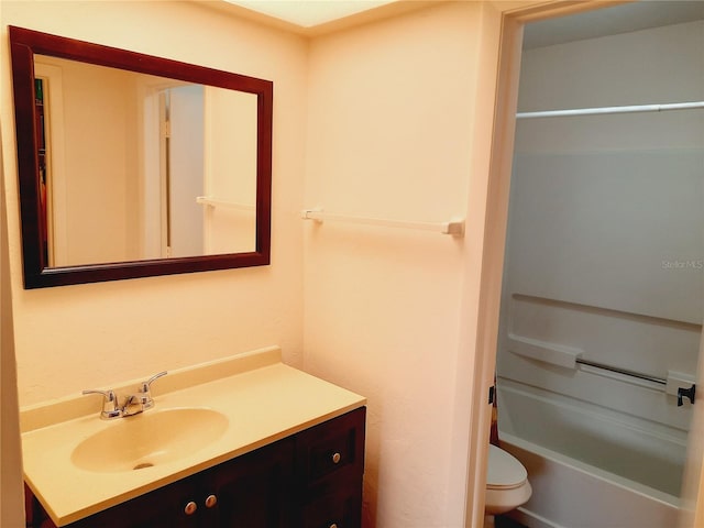 bathroom with a tub to relax in, vanity, and toilet