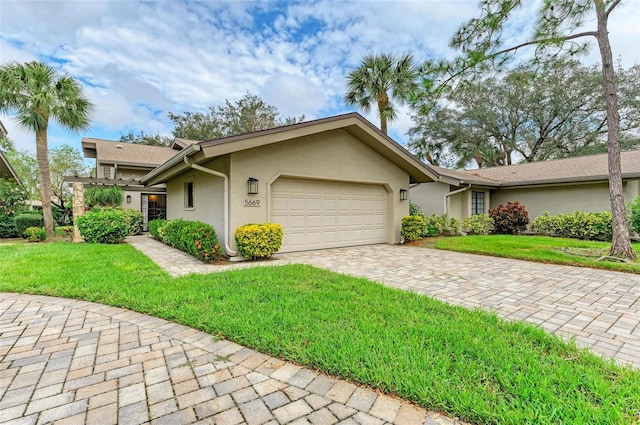 single story home featuring a garage and a front yard