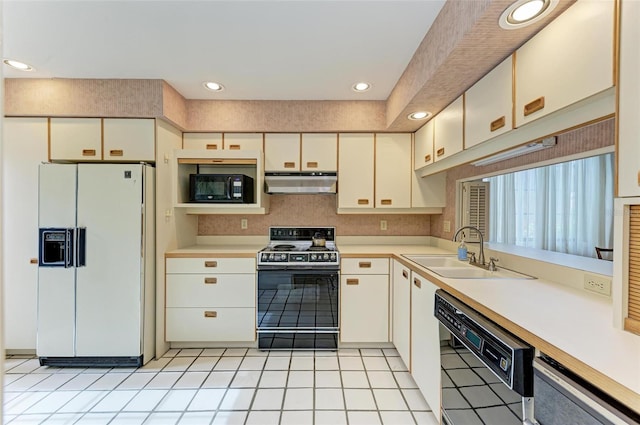 kitchen featuring white cabinets, black appliances, sink, and light tile patterned flooring