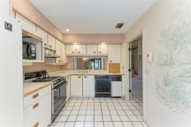 kitchen featuring black appliances, sink, light tile patterned floors, and white cabinets