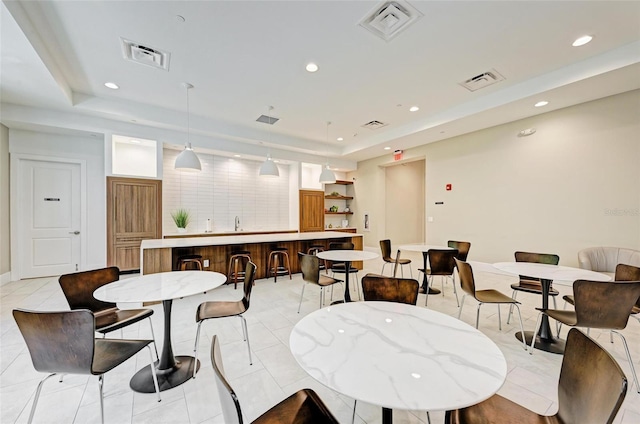 tiled dining room featuring a raised ceiling