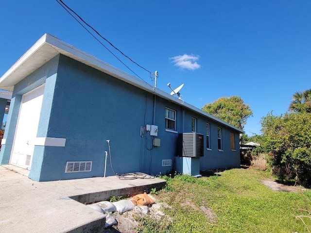 1308 72nd St E, Palmetto, FL 34221 - view of side of property featuring stucco siding, a lawn, and a garage