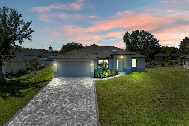 7648 Totem Ave, North Port, FL 34291 - view of front facade featuring stucco siding, decorative driveway, a yard, a garage, and a shingled roof