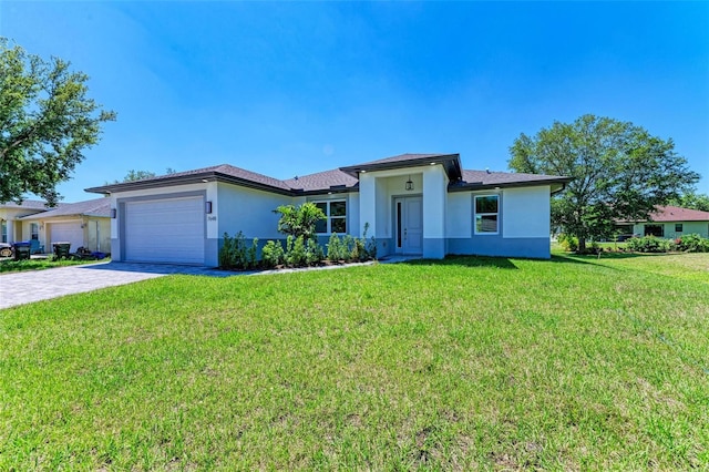 7648 Totem Ave, North Port, FL 34291 - prairie-style house with stucco siding, an attached garage, decorative driveway, and a front lawn