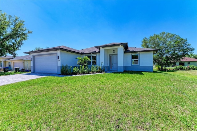 7648 Totem Ave, North Port, FL 34291 - prairie-style house featuring stucco siding, an attached garage, decorative driveway, and a front lawn