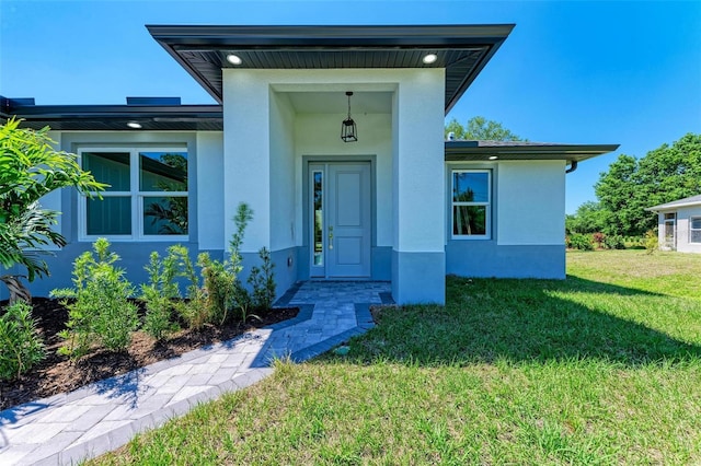 7648 Totem Ave, North Port, FL 34291 - view of exterior entry featuring stucco siding and a lawn