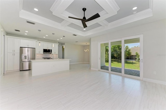 unfurnished living room with crown molding, ceiling fan, and a raised ceiling