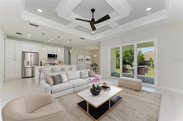 living room featuring ornamental molding, a tray ceiling, ceiling fan, and coffered ceiling