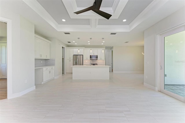 kitchen with a kitchen island, white cabinetry, decorative backsplash, and appliances with stainless steel finishes