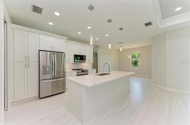 kitchen featuring white cabinets, sink, a kitchen island with sink, pendant lighting, and appliances with stainless steel finishes