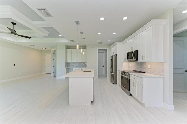 kitchen featuring sink, appliances with stainless steel finishes, a kitchen island with sink, white cabinets, and pendant lighting