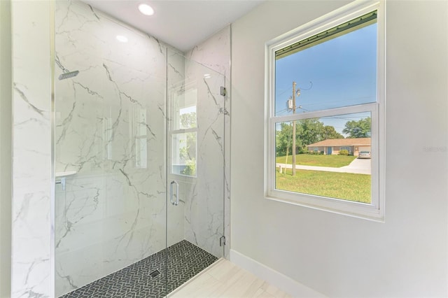 bathroom featuring tile patterned flooring, a healthy amount of sunlight, and a shower with shower door