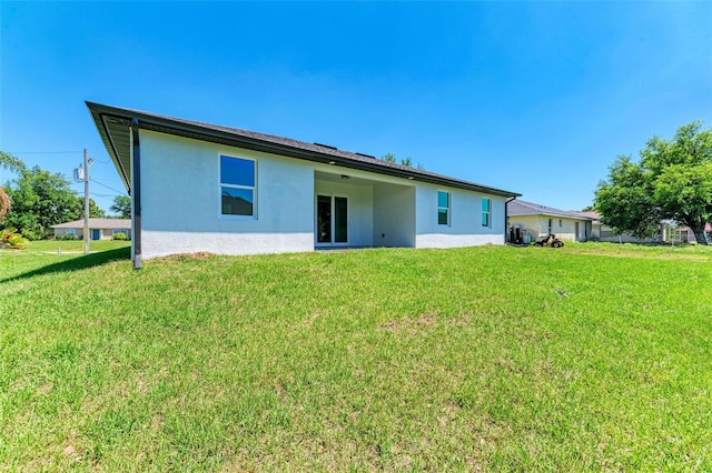 back of property featuring a lawn