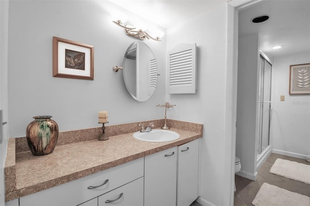 bathroom with vanity, tile patterned floors, toilet, and walk in shower