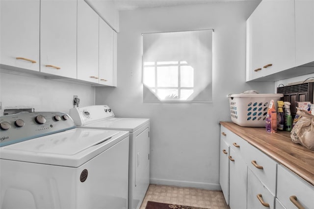 clothes washing area featuring cabinets and washer and dryer