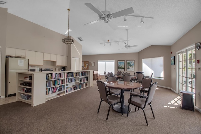 dining room with light carpet, vaulted ceiling, and plenty of natural light