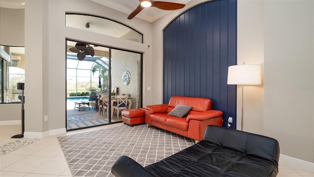 living room featuring ceiling fan, ornamental molding, and light tile patterned floors