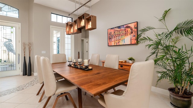 tiled dining area featuring a chandelier and a high ceiling