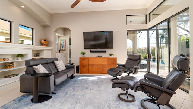 living room with ornamental molding, ceiling fan, a healthy amount of sunlight, and light tile patterned flooring