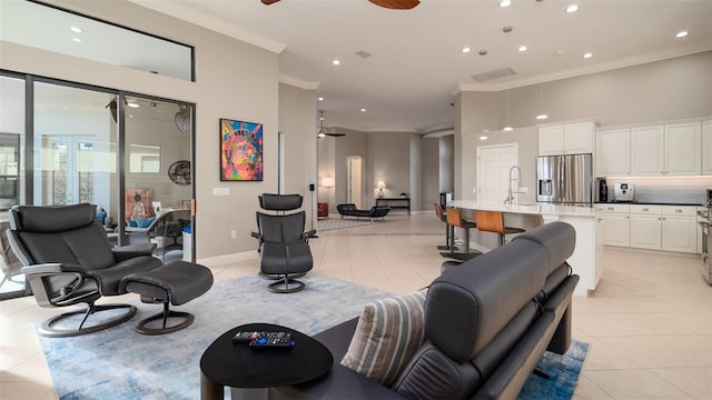 living room with ceiling fan, crown molding, and light tile patterned flooring