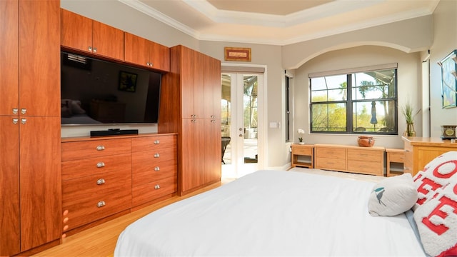 bedroom featuring access to exterior, light wood-type flooring, crown molding, and french doors