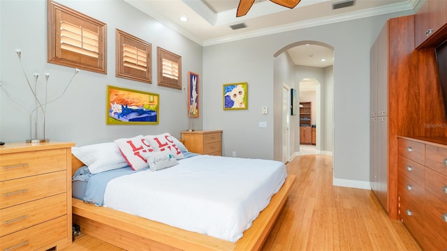 bedroom with light hardwood / wood-style floors, ceiling fan, and ornamental molding